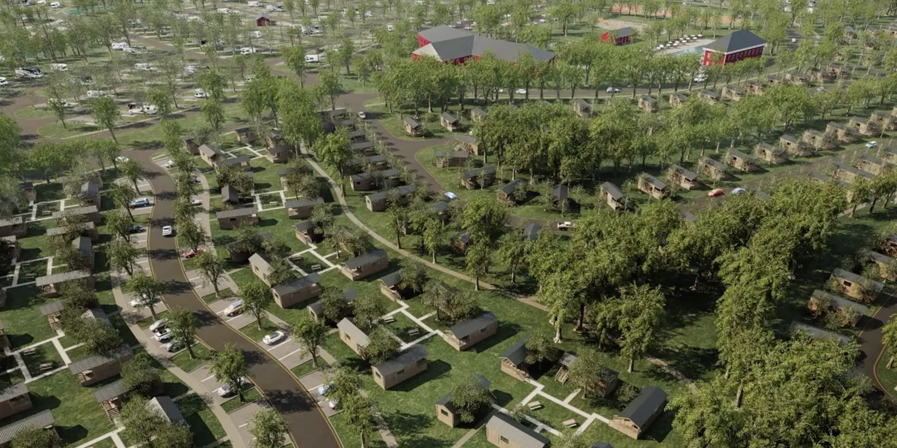 Aerial view of a cabin-style RV resort integrated into a lush green landscape