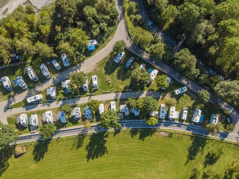 A large grassy field with many small trailers parked in it.